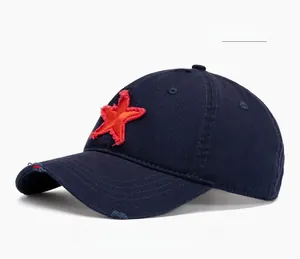 Close-up of distressed navy blue cotton baseball cap with red star patch and worn edge detail