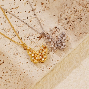 Detailed macro view of hollow butterfly pendant necklaces in silver and gold plating