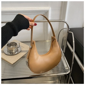 Detail of camel crescent underarm bag with silver hardware and smooth matte finish