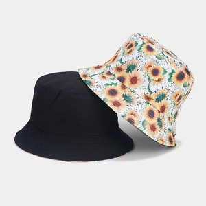 Close-up of black and sunflower print reversible bucket hats in cotton canvas fabric