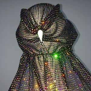 Detail of high-density iridescent rhinestones on black mesh fabric showing brilliant shine