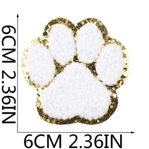 Detailed close-up of 6cm white chenille paw patch with gold sequin border and embroidery