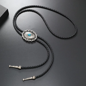 Detail of flower-shaped bolo tie with turquoise stone and black braided leather cord
