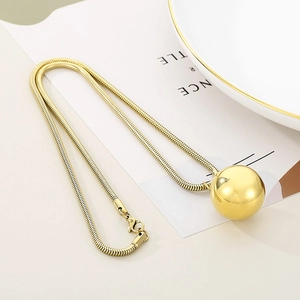Exaggerated golden snake chain necklace with a large polished metal ball pendant for women