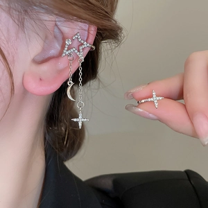 Detailed view of silver star and moon tassel earrings set with sparkling zircon stones