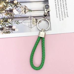 Close-up of bright green braided leather keychain with polished silver metal clasp