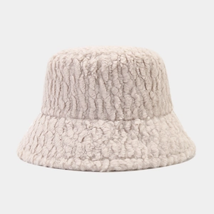 Detailed texture of fuzzy beige lamb wool fabric on a minimalist winter bucket hat