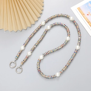 Detail of colorful metal rings and imitation pearls crossbody phone strap with spring clasps