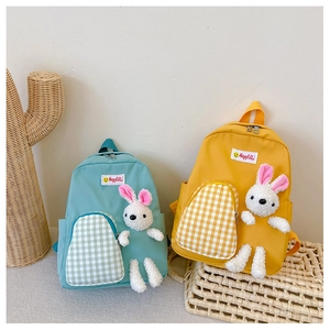 Detail of cartoon children backpacks with bunny dolls and checkered pockets in vibrant colors
