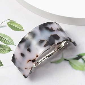 Macro shot of U-shaped acetate hair clip with leopard pattern and silver metal spring