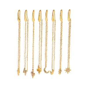 Detail of 18K gold stainless steel tassel earrings with moon, star, and snake charms