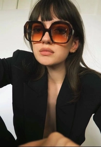 Macro detail of oversized tortoiseshell sunglasses with gradient orange lenses