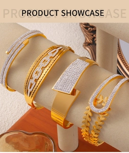 Détail de quatre bracelets dorés avec découpes géométriques et zircons étincelants
