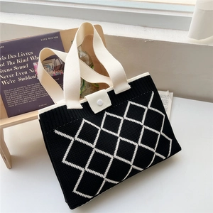 Gros plan du sac cabas en tricot noir et blanc avec motif losange et anse épaisse crème