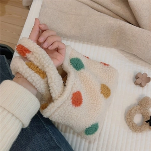Close-up of fluffy sherpa handbag with colorful polka dots and integrated handle