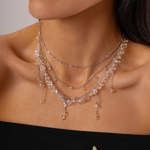 Close-up of three-layer silver tassel necklace with transparent crystal stones on model