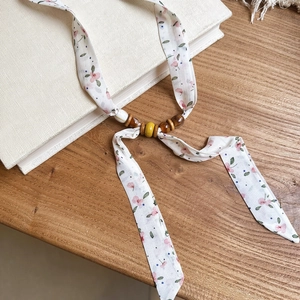 Detailed view of the floral print chiffon ribbon necklace with natural wooden and acrylic beads