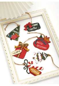 Detailed view of hand-painted wooden Christmas tree ornaments with festive greetings and twine