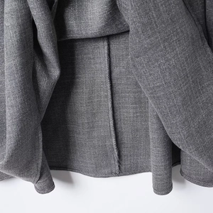 Detailed macro view of the inner seam and woven fabric texture of the gray skirt set