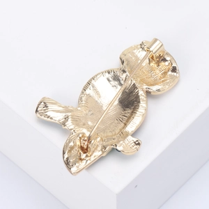 Detailed back view of a golden alloy owl brooch showing a secure metal safety pin clasp