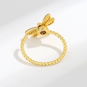 Drehbarer Libellen-Ring mit Zirkonia-Besatz und gedrehtem Goldband auf weißem Grund