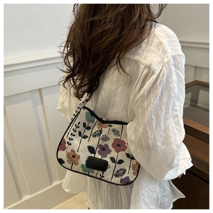 Detailed texture of vintage floral linen tote bag featuring a black rectangle logo plate