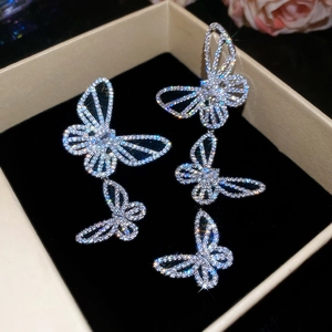 Macro shot of silver butterfly tassel earrings with sparkling crystals in a jewelry box