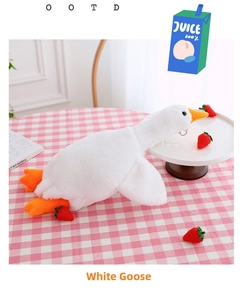 Detail of soft white goose plush bag with orange beak and feet on a pink checkered cloth