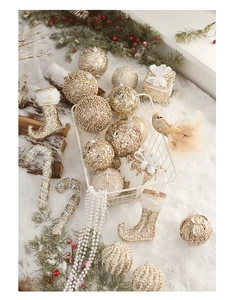 Detailed view of champagne gold and white Christmas ornaments set in snow