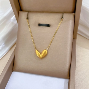 Detail view of gold leaf pendant on a delicate cable chain inside a premium jewelry box