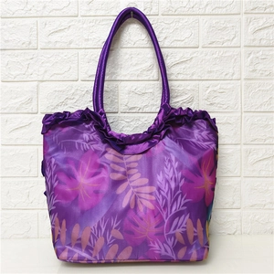 Detail of purple floral shoulder bag with tropical leaf print and ruffled top edge design
