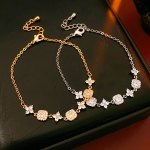 Detail view of gold and silver plated floral square bracelets with zircon inlay on leather