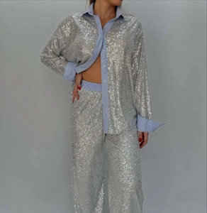 Detail of silver sequined blazer and striped cuffs on a loose-fit two-piece outfit
