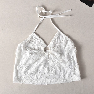 Détail d'un crop top blanc à dos nu avec textures ajourées et boucle en métal chromé