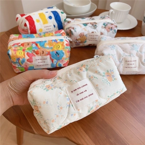 Detailed view of soft quilted cotton makeup bags with floral and cute bear patterns