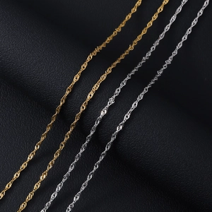 18K gold and silver water wave chain necklaces on black leather background