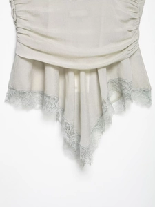 Detail shot of delicate eyelash lace trim on pleated georgette fabric in pale mint