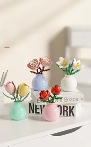 Four colorful building block flower arrangements in mini vases on a white book