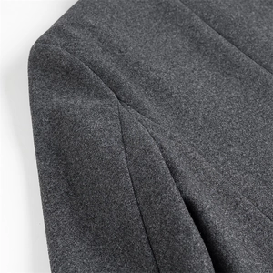 Macro view of dark grey wool coat showing premium fabric texture and shoulder stitching detail
