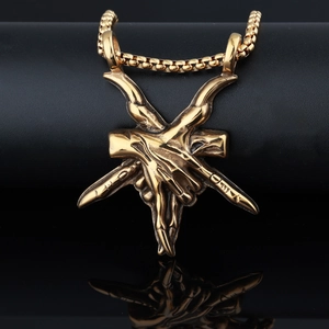 Macro shot of golden Baphomet goat head pendant in gothic punk style on reflective surface