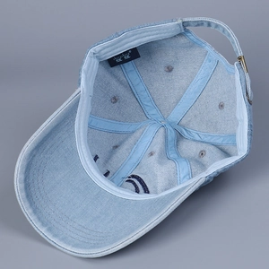 Detailed inner view of light blue denim baseball cap featuring metal buckle and reinforced seams