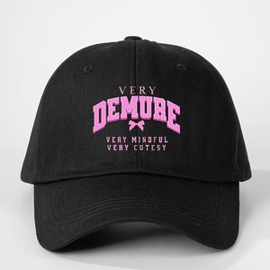 Close-up of black cotton baseball cap with pink Very Demure print and curved brim