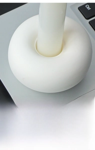 Detailed macro view of a white ceramic donut candle holder with a smooth matte finish
