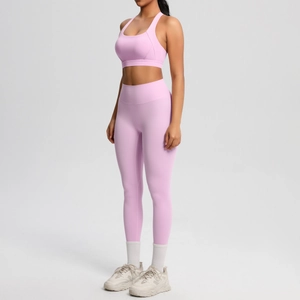 Conjunto rosa de leggings de yoga de cintura alta y sujetador deportivo visto a 45 grados