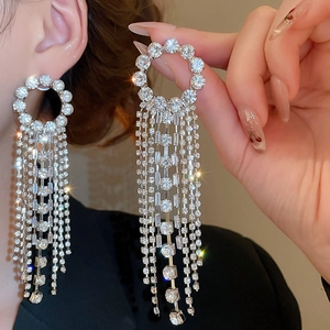 Macro detail of elegant silver round hoop earrings with sparkling long tassel rhinestones