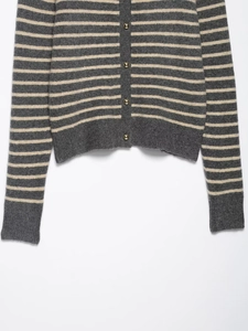 Detail view of striped knit cardigan showing golden buttons and ribbed texture