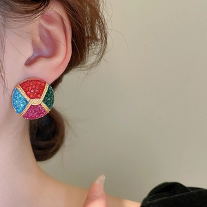 Close-up of model wearing colorful pave crystal round stud earrings in vintage gold style