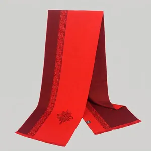 Close-up of red and wine wool blend scarf with Chinese knot pattern and short fringes