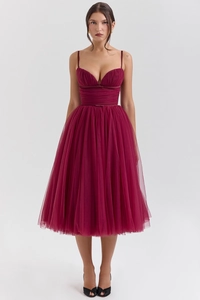 Detail view of burgundy tulle dress showing V-neck bodice and waist bow decoration