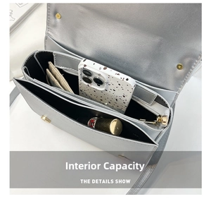 Detail view of silver rivet handbag internal capacity with compartments for phone and makeup